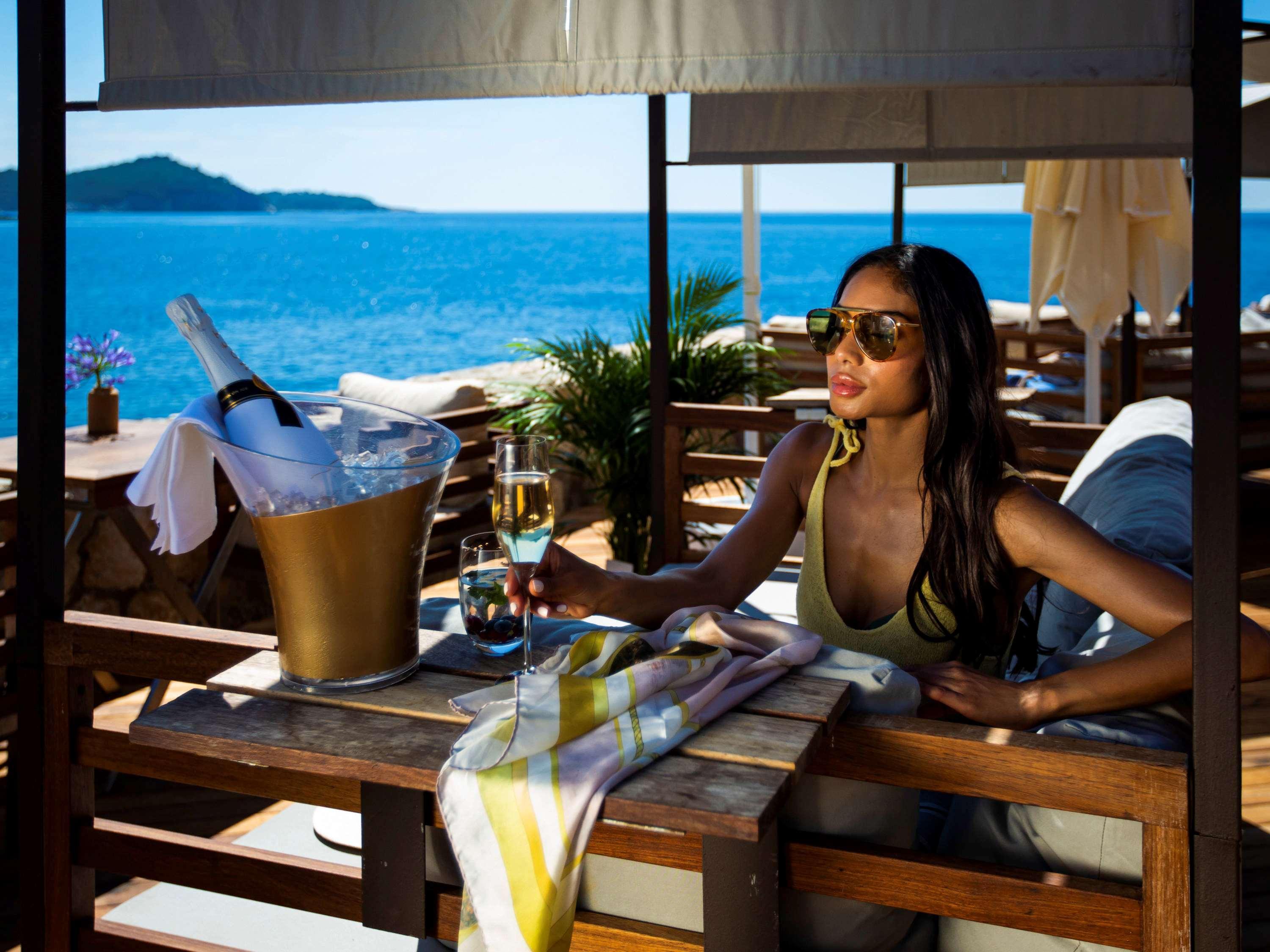 Hotel Rixos Premium Ragusa Esterno foto A woman at a beach club